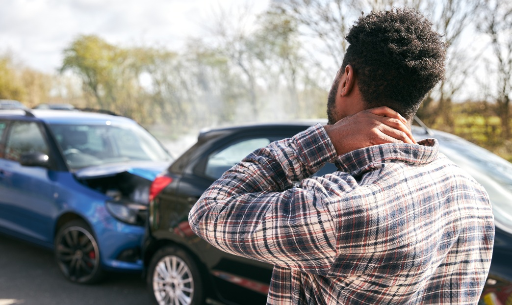 Man holding sore neck after a car crash - whiplash