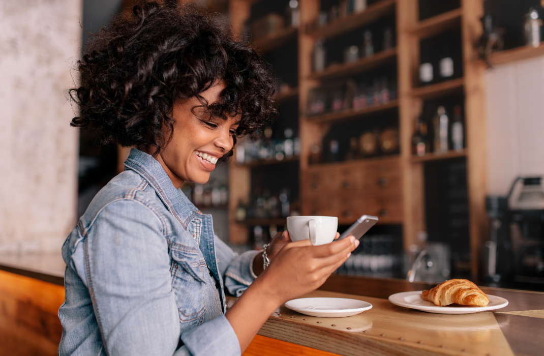 woman in coffee shop looking down at phone