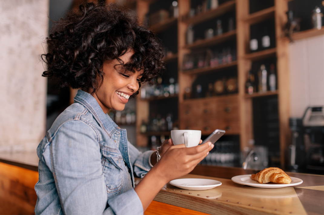 woman in coffee shop looking down at phone