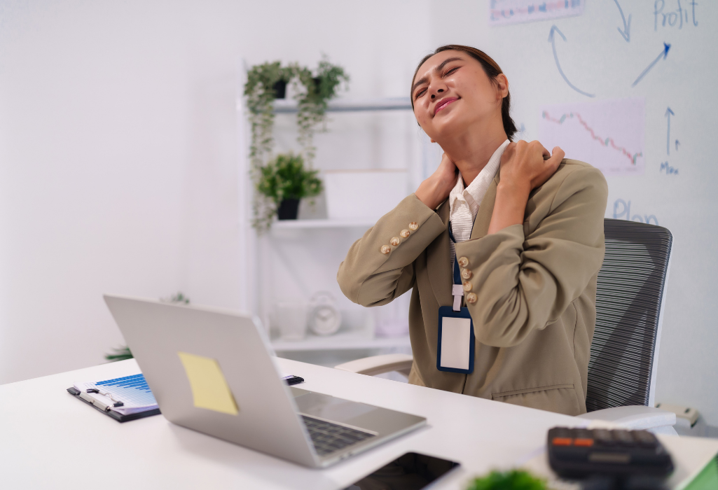 woman experiencing neck pain at her desk